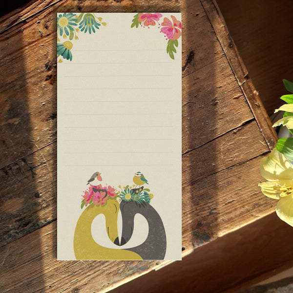 A paper notepad featuring Rollerdog's Hounds of Love illustration, photographed on a wooden table