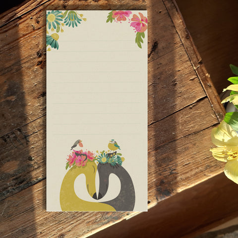 A paper notepad featuring Rollerdog's Hounds of Love illustration, photographed on a wooden table
