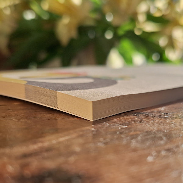 A close up view of a Hounds of Love notepad, showing the thickness of the pad and the light texture of the paper