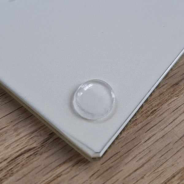 Close up view of the base of a Rollerdog glass chopping board, showing the silicone foot