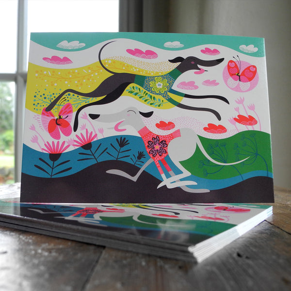 A stack of Zoomies postcards on a wooden surface