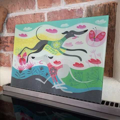 A Zoomies glass chopping board photographed against a  brick wall, leaning on an oven hob