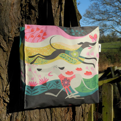 A Zoomies tote bag by Rollerdog, shown outside next to a tree
