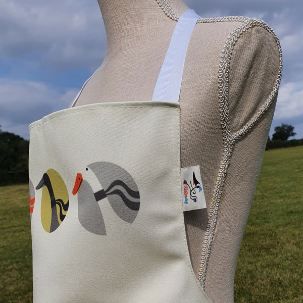 Close up view of a Three Ducks from Derbyshire apron, showing the fabric, Rollerdog label and white halter neck tie