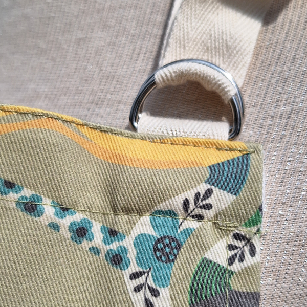 A close up view of a Bloomin Hounds apron showing the D-ring neck tie