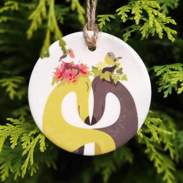 A hounds of Love ceramic decoration, photgraphed hanging from a cypress tree