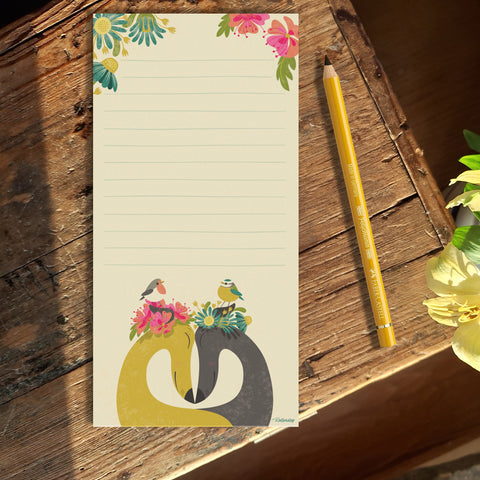 A paper notepad featuring Rollerdog's Hounds of Love illustration, photographed on a wooden table