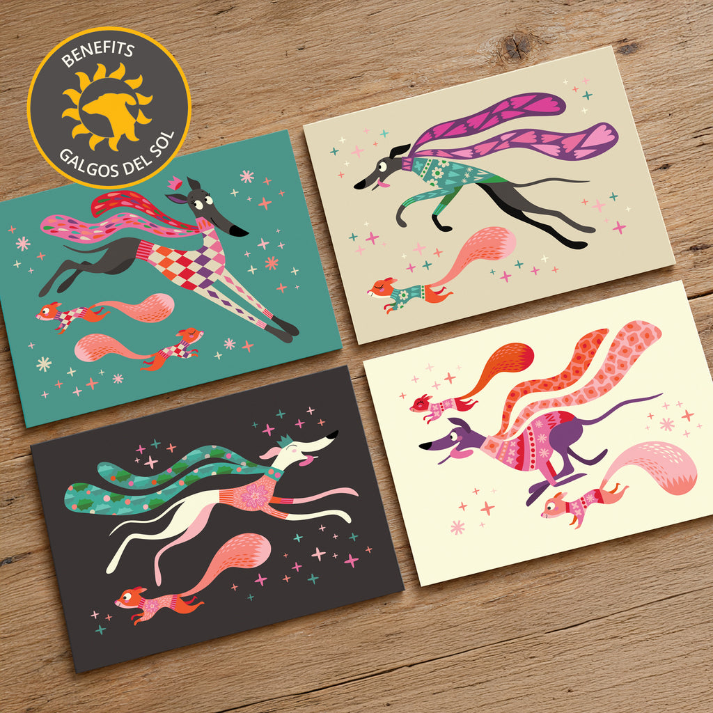 Four A6 sized Christmas cards with illustrated sighthounds and squirrels in bright patterned colours, arranged on a wooden surface. A circular badge in the top-left reads 'BENEFITS GALGOS DEL SOL'.