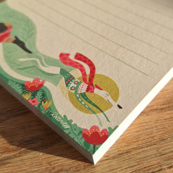 A close up view of a 'Spring Zoomies' notepad, showing the colourful illustration of a pair of hounds running through flowers