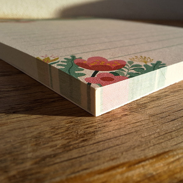 A close up view of a 'Spring Zoomies' notepad, showing the colourful illustration of flowers