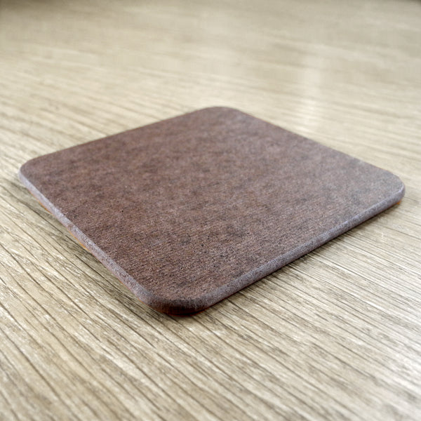 The back of a square Rollerdog coaster, photographed on a wooden surface