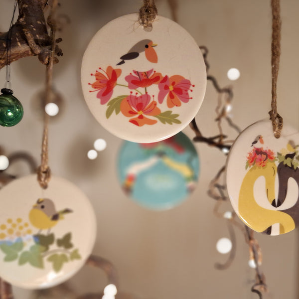 A group of all of the ceramic decorations available on Rollerdog, shot on a twiggy Christmas tree with fairy lights