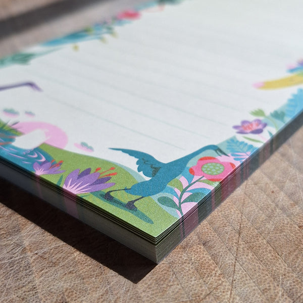 Paper notepad featuring'Derbyshire Ducks' illustration, a cute and colourful floral design with Indian runner ducks, photographed on a wooden surface