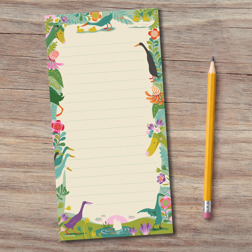Notpad featuring Indian runner ducks and flowers, set on a wooden surface with a yellow pencil
