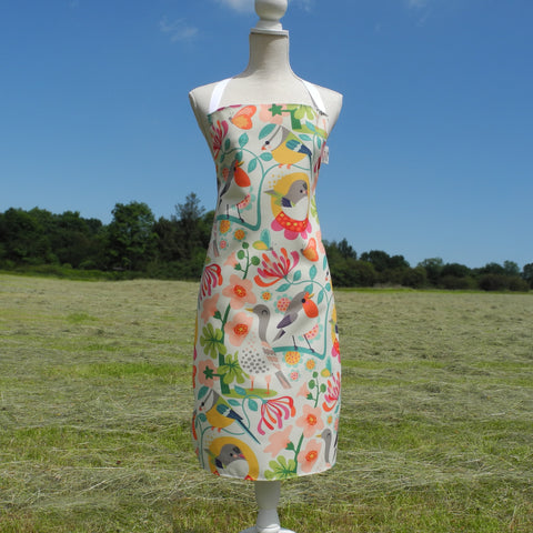 A Bright Birds apron by Rollerdog, displayed on a mannequin in the countryside