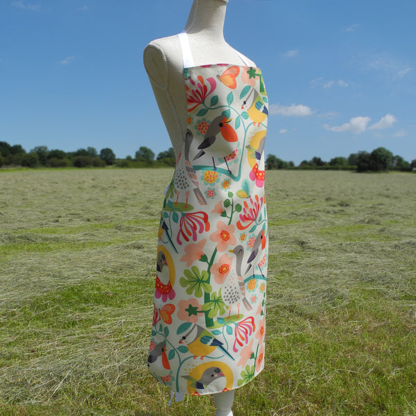 The side view of a Bright Birds apron by Rollerdog, displayed on a mannequin in the countryside