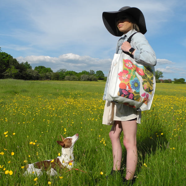A Dog Rose tote bag by Rollerdog, showing it in use as a shoulder bag by the model with her whippet