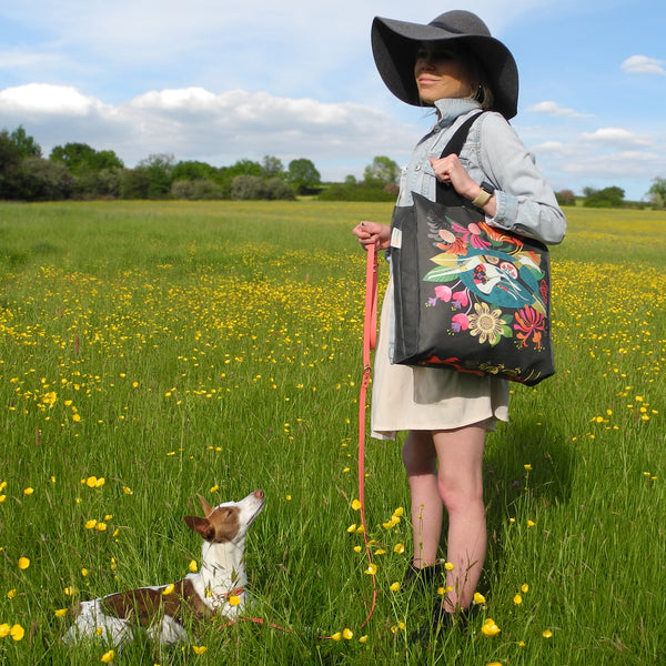 A Flower Bed tote bag in use by a model and her whippet in the countryside