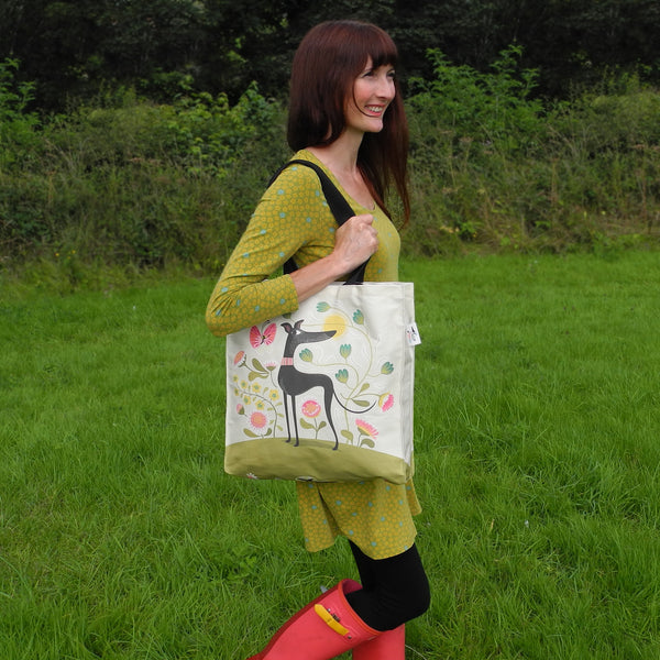 A Freddie the tripod tote bag by Rollerdog in use as a shoulder bag, outside in the countryside