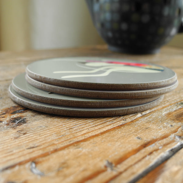 A stack of 4 Rollerdog Greyhound & Whippet coasters on a wooden surface