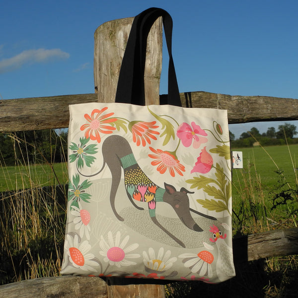 Greta tote bag by Rollerdog, shown on a fence post in the countryside