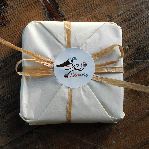 A set of Rollerdog coasters wrapped in tissue paper and raffia