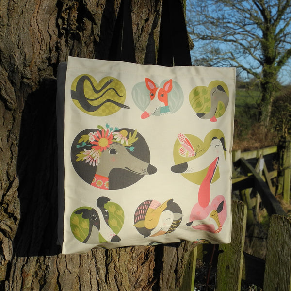 A Noses & Poses tote bag by Rollerdog, next to a tree in the countryside