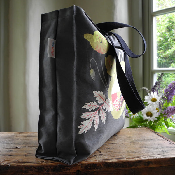 The side view of a Rollerdog Poppy the greyhound tote bag showing the black straps