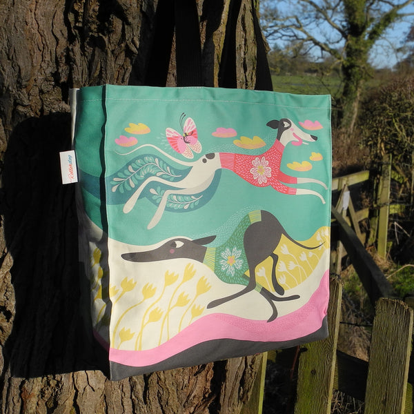 A Zoomies tote bag by Rollerdog, shown outside next to a tree