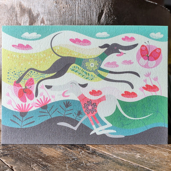 A close up view of a Rollerdog Zoomies postcard on textured matt card